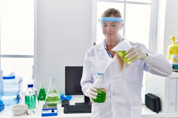 Mujer Rubia Joven Con Uniforme Científico Que Mide Líquido Laboratorio — Foto de Stock