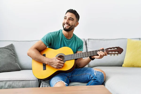Jovem Árabe Homem Tocando Guitarra Clássica Sentado Sofá Casa — Fotografia de Stock