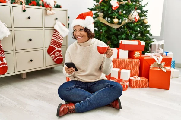 Middle Age Hispanic Woman Using Smartphone Drinking Coffee Sitting Christmas — Stock Photo, Image