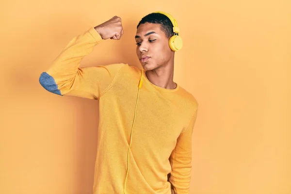 年轻的非洲裔美国人 用耳机听音乐时 强壮的人表现出臂膀肌肉 自信而自豪 — 图库照片