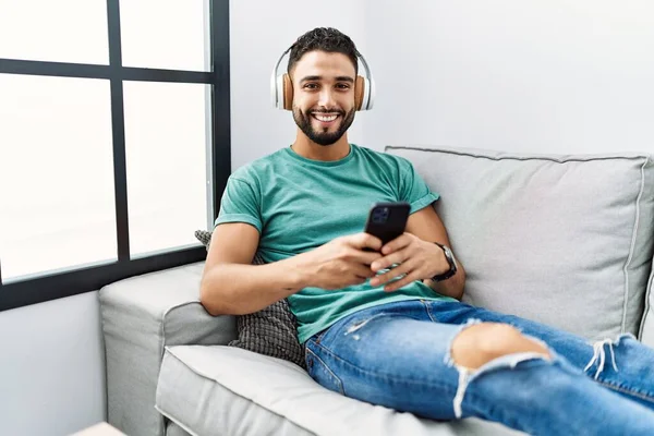 Genç Arap Adam Evdeki Kanepede Oturmuş Müzik Dinliyor — Stok fotoğraf