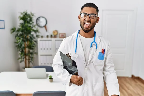 Homem Indiano Jovem Vestindo Uniforme Médico Estetoscópio Furando Língua Feliz — Fotografia de Stock