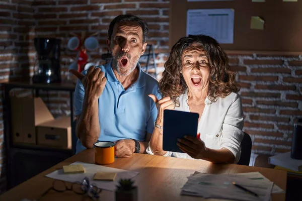 Middle Age Hispanic Couple Using Touchpad Sitting Table Night Surprised — Foto Stock