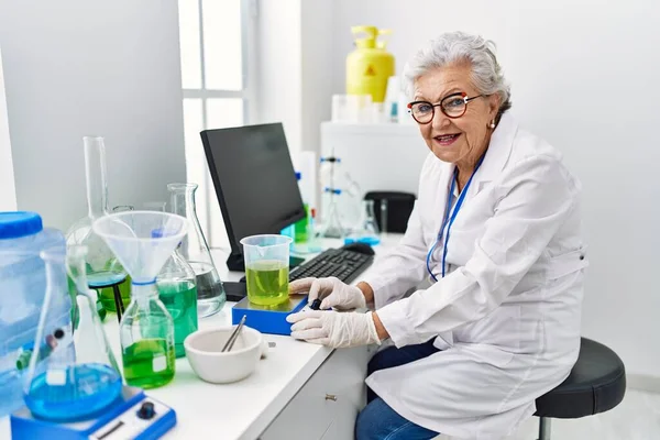 Starsza Siwowłosa Kobieta Mundurze Naukowca Waży Płyn Laboratorium — Zdjęcie stockowe