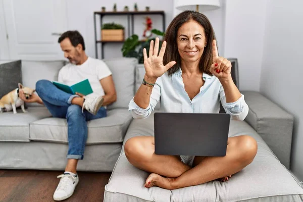 Hispanic Middle Age Couple Home Woman Using Laptop Showing Pointing — Stok Foto