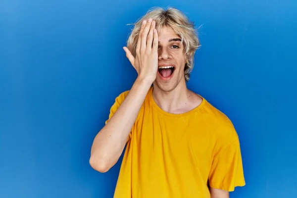 Jeune Homme Moderne Debout Sur Fond Bleu Couvrant Oeil Avec — Photo