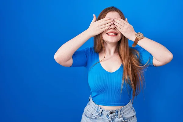 Zrzavá Žena Stojící Nad Modrým Pozadím Zakrývající Oči Veselýma Legračníma — Stock fotografie