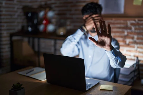 Young Hispanic Man Beard Working Office Night Covering Eyes Hands — Stockfoto