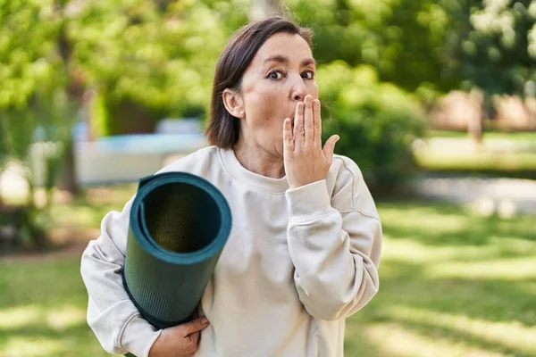 Middle Age Hispanic Woman Holding Yoga Mat Park Covering Mouth — Stock Photo, Image