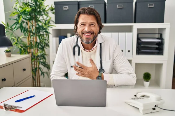 Красивий Чоловік Середнього Віку Лікар Працює Клініці Посміхаючись Сміючись Важко — стокове фото