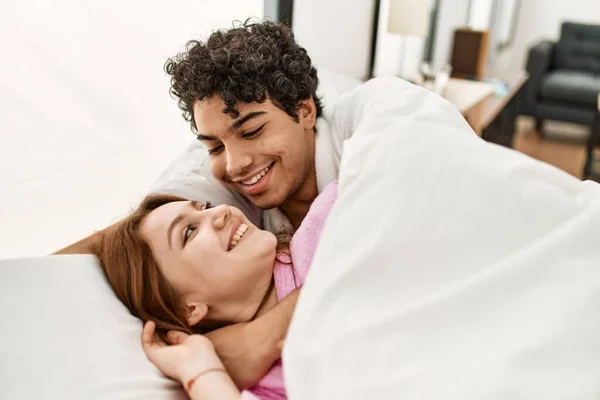 Pareja Joven Sonriendo Feliz Abrazándose Acostada Cama Dormitorio — Foto de Stock