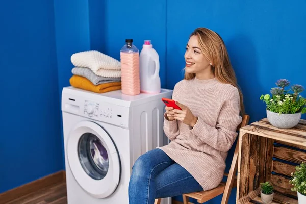 Çamaşır Odasında Çamaşır Makinesi Bekleyen Akıllı Telefon Kullanan Genç Bir — Stok fotoğraf
