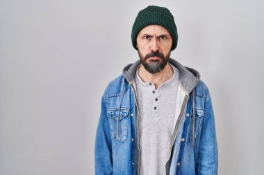Young hispanic man with tattoos wearing wool cap depressed and worry for distress, crying angry and afraid. sad expression. 