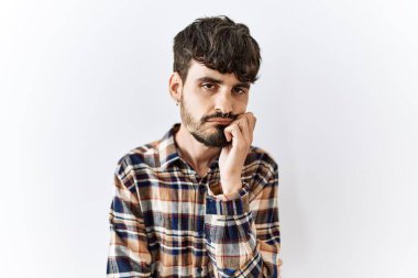 Hispanic man with beard standing over isolated background thinking looking tired and bored with depression problems with crossed arms. 