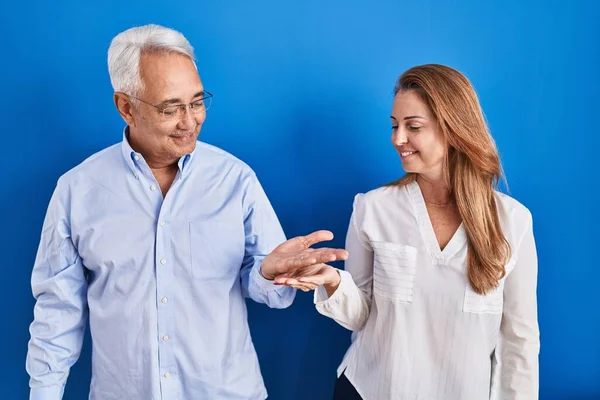 Middle Age Hispanic Couple Standing Blue Background Smiling Showing Both — kuvapankkivalokuva