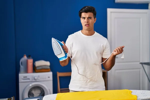 Homem Hispânico Segurando Ferro Elétrico Sem Noção Expressão Confusa Conceito — Fotografia de Stock