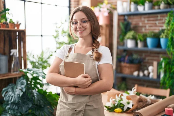 Joven Florista Mujer Rubia Sonriendo Confiado Sosteniendo Cuaderno Floristería —  Fotos de Stock