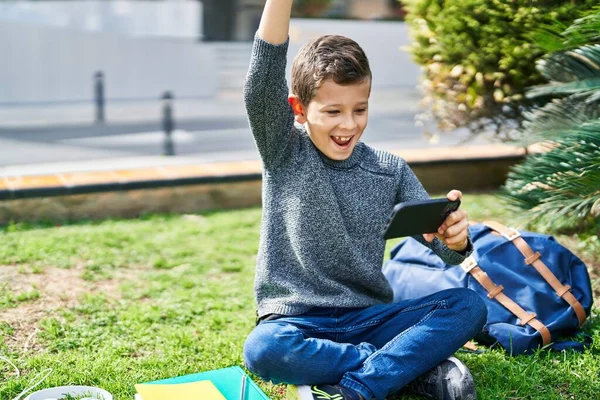 Niño Rubio Usando Teléfono Inteligente Sentado Hierba Parque —  Fotos de Stock