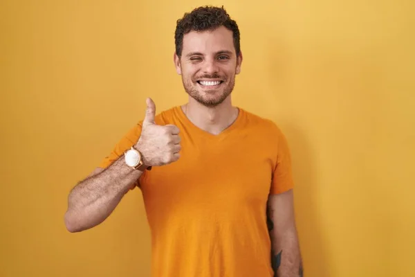 Homem Hispânico Jovem Sobre Fundo Amarelo Fazendo Polegares Felizes Gesto — Fotografia de Stock