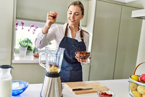 Young Blonde Woman Smiling Confident Pouring Dates Blender Kitchen — Foto Stock