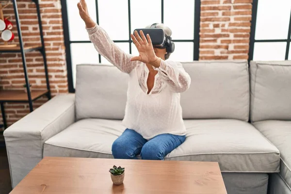 中年妇女在家用虚拟现实眼镜玩电子游戏 — 图库照片