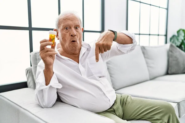 Senior Man Holding Pills Pointing Fingers Showing Advertisement Surprised Face — Stock fotografie