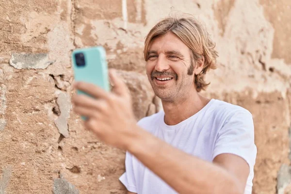 Genç Sarışın Adam Gülümsüyor Kendine Güveni Tam Sokakta Akıllı Telefonun — Stok fotoğraf