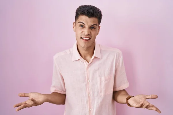 Young Hispanic Man Standing Pink Background Clueless Confused Open Arms — Stockfoto