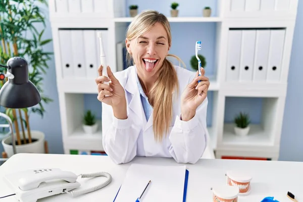 Beautiful Dentist Woman Holding Ordinary Toothbrush Electric Toothbrush Sticking Tongue — Stockfoto