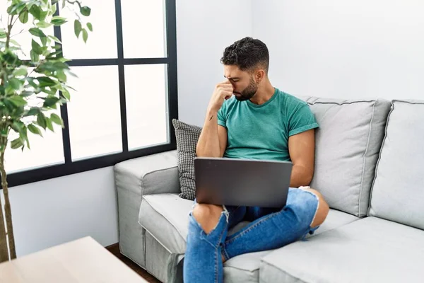 Evde Bilgisayar Bilgisayarı Kullanan Sakallı Genç Yakışıklı Adam Kanepede Oturuyor — Stok fotoğraf