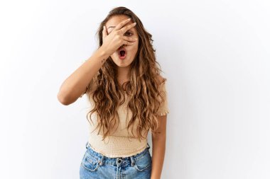 Güzel İspanyol kadın, arka planda mahcup bir ifadeyle parmaklarının arasından bakarak yüzünü ve gözlerini kapatarak şoka göz gezdirirken izole bir şekilde dikilir.. 