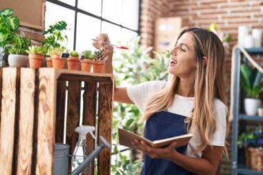 Çiçekçide kendine güvenen genç sarışın bir çiçekçi.