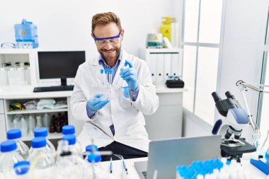 Orta yaşlı, labaratuarda çalışan bilim adamı üniforması giyen bir İspanyol.