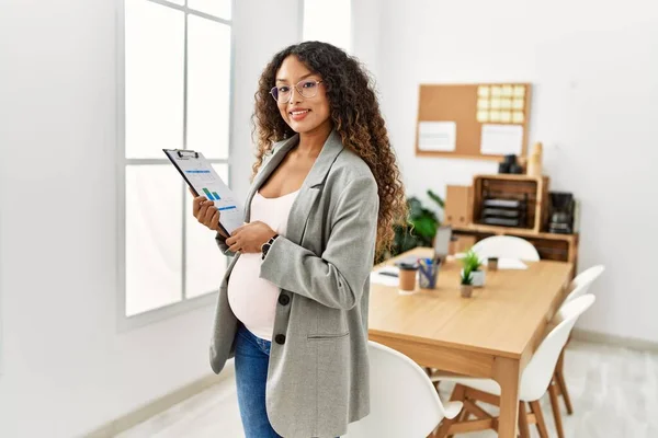 Young Latin Woman Pregnant Smiling Confident Holding Clipboard Office — Foto Stock