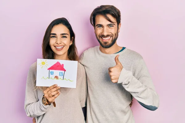 Junge Hispanische Paar Hält Haus Zeichnen Lächelnd Glücklich Und Positiv — Stockfoto