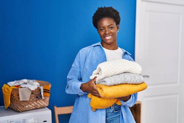 African American Woman Smiling Confident Holding Folded Clothes Laundry Room — Fotografia de Stock