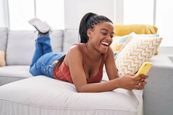 Afro Amerikaanse Vrouw Met Behulp Van Smartphone Liggend Bank Thuis — Stockfoto