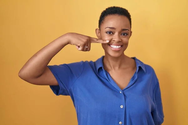 Африканська Американка Стояла Над Жовтим Фоном Показуючи Пальцем Обличчя Носа — стокове фото