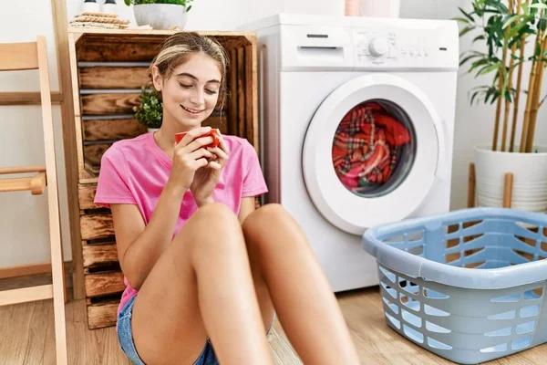 Çamaşır Odasında Çamaşır Makinesini Bekleyen Beyaz Bir Kadın Kahve Içiyor — Stok fotoğraf