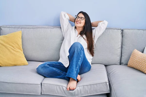 Young Hispanic Woman Relaxed Hands Head Sitting Sofa Home — Stok fotoğraf