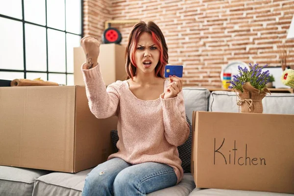 Young Caucasian Woman Moving New Home Holding Credit Card Annoyed — Foto de Stock
