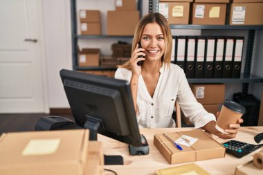 Young hispanic woman ecommerce business worker talking on smartphone at office