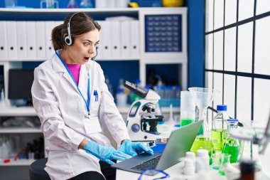 Laboratuvarda çalışan İspanyol kadın korkmuş ve ağzı açık kalmış, şaşırmış ve şaşırmış. 