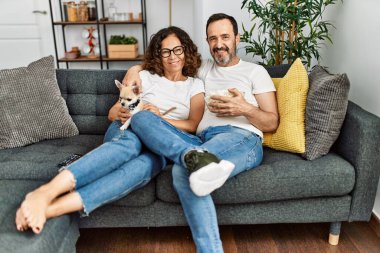 Orta yaşlı İspanyol çift film izliyor ve evde kanepede oturmuş patlamış mısır yiyor..