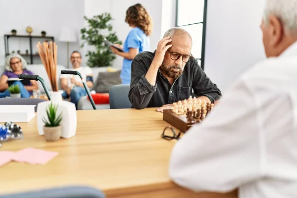 Two Retired Man Concentrate Playing Chess Nurse Home — Stockfoto