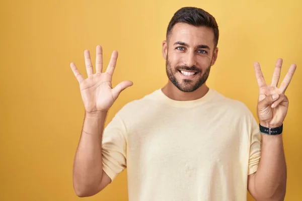 Hezký Hispánec Stojící Nad Žlutým Pozadím Ukazující Ukazující Prsty Číslo — Stock fotografie