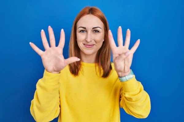 Jonge Vrouw Staande Blauwe Achtergrond Tonen Wijzen Met Vingers Nummer — Stockfoto