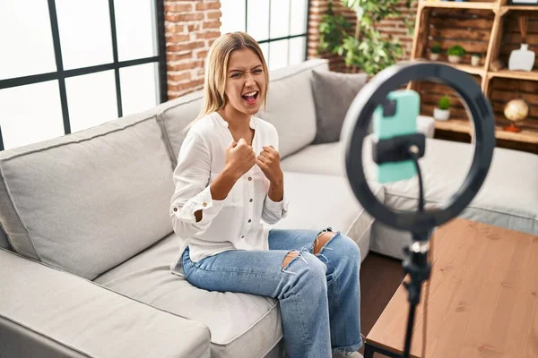 Young Blonde Woman Recording Vlog Tutorial Smartphone Home Celebrating Surprised — Stockfoto