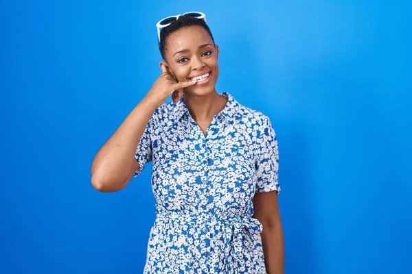 Mujer Afroamericana Pie Sobre Fondo Azul Sonriendo Haciendo Gesto Telefónico —  Fotos de Stock