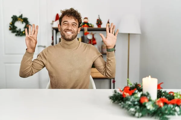 Noel Süslemesi Masasında Oturan Sakallı Yakışıklı Genç Adam Dokuz Numarayı — Stok fotoğraf